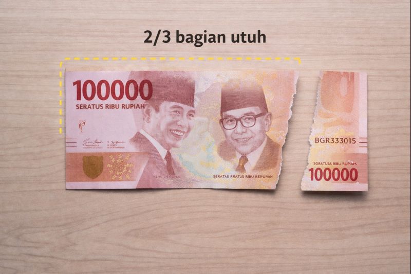 Ilustrasi pelipatan uang menjadi 3 bagian untuk membantu penilaian keutuhan minimal 2/3 sesuai ketentuan